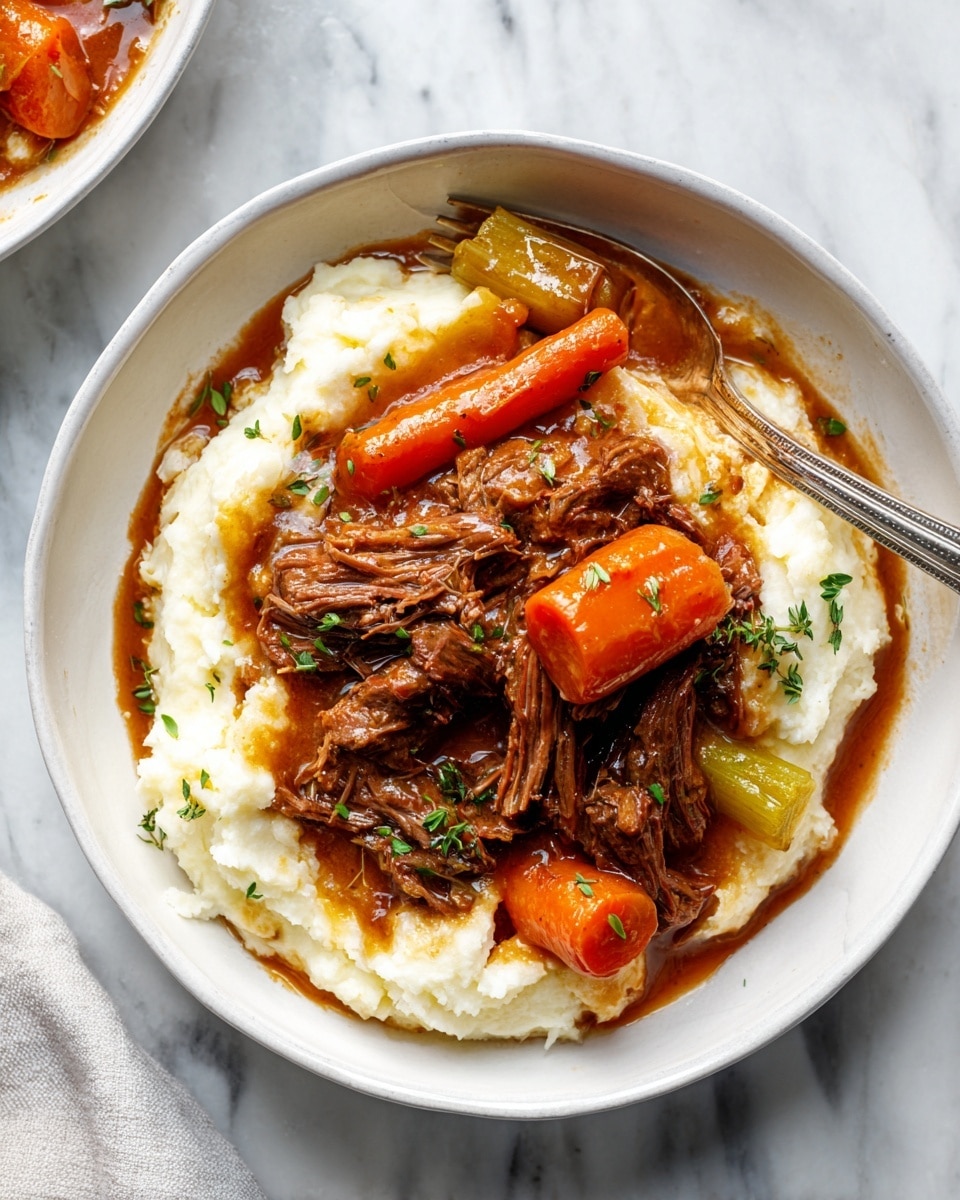 A white bowl holds a comforting dish made of three main layers. The bottom layer is creamy white mashed potatoes with a smooth, slightly fluffy texture. On top of the mashed potatoes lies a rich brown beef stew with tender, shredded beef pieces showing fibers and softness. Large orange carrot chunks and a few soft celery sticks are mixed in the stew, adding bright color and texture. The stew's glossy brown sauce spreads lightly over the mashed potatoes, and small green herb leaves are sprinkled on top for contrast. A silver fork rests on the right side of the bowl, all placed on a white marbled surface. Photo taken with an iphone --ar 4:5 --v 7
